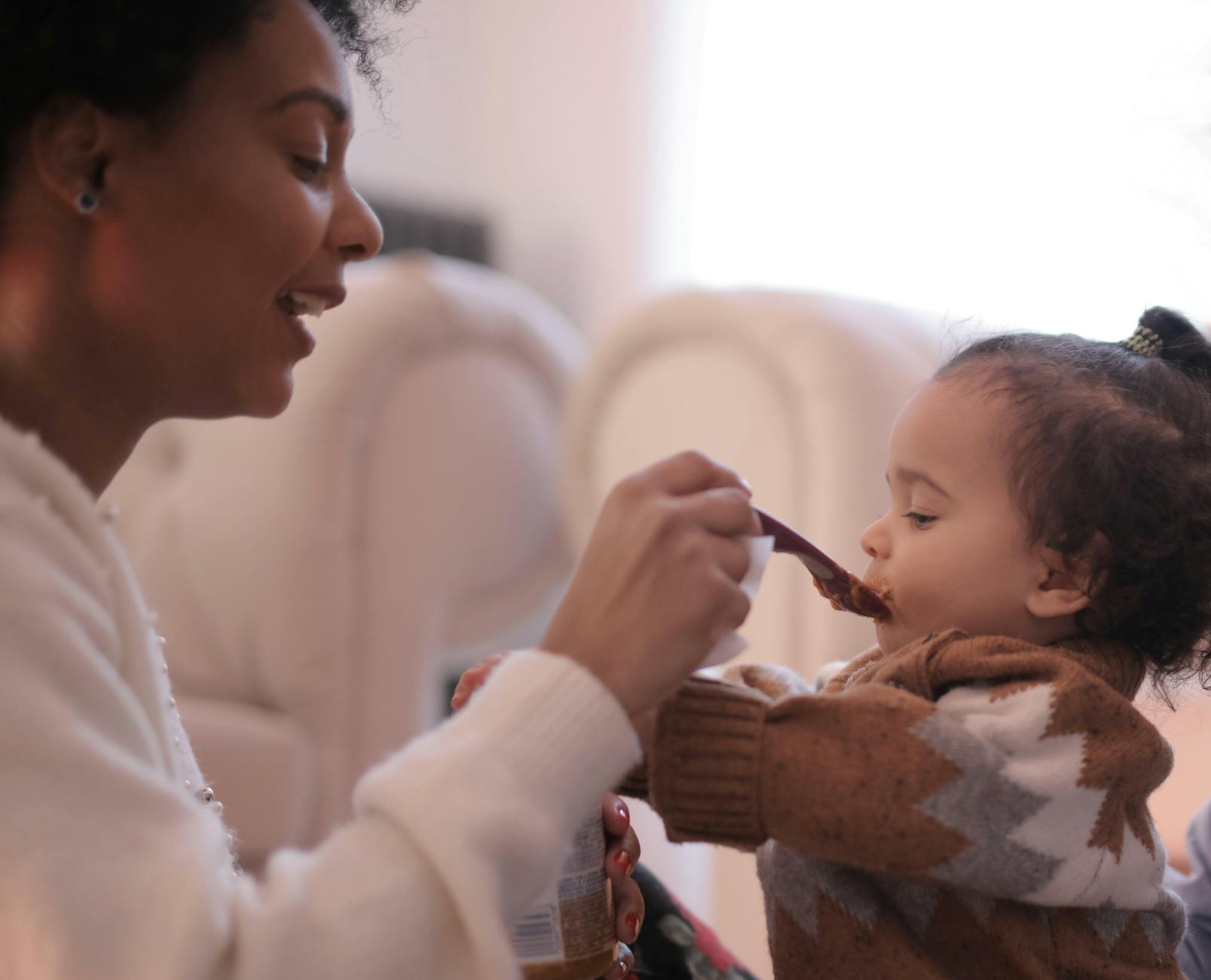 photo of woman feeding her child