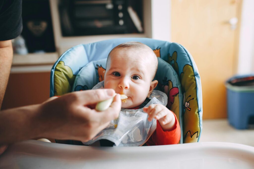 little baby eating yummy food from spoon